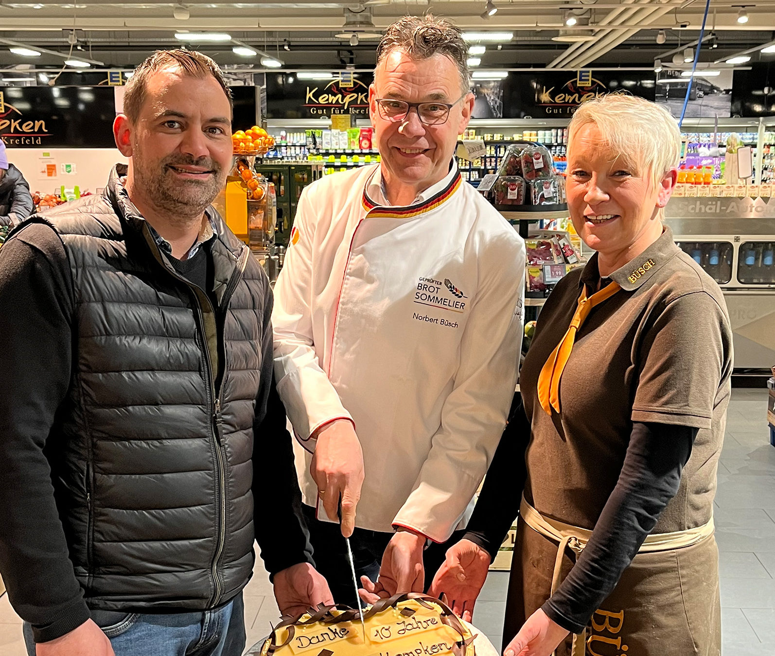 zum 10jährigen Jubiläum von Edeka Kempken gratulieren Norbert Büsch und Annett Jeratsch von der Handwerksbäckerei Büsch dem Inhaber Stefan Kempken.