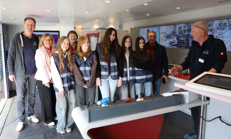 Praxis statt Theorie: Berufe-Coach Claudio Schmickler (r.) erklärt den Schülerinnen die Stationen im InfoTruck. Dabei schauten ihnen über die Schulter (v.l.): Christan Déus, Teamleiter Ausbildung bei tkMSS, Heike Zeitel und Elisabeth Schulte vom Unternehmerverband und Lehrer Uwe Brinkmann. Quelle wie folgt an: Foto: Unternehmerverband