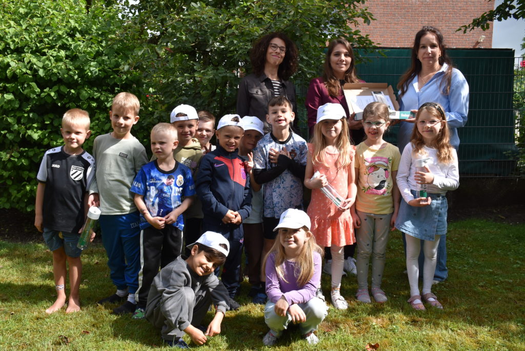 Die Kinder der Maulwurf- und der Igelgruppe der KiTa Sankt Nikolaus Stralsunder Straße in Wesel bekommen gemeinsam mit Erzieherin Svenja Sieben (ganz rechts) von Anne Janssen und Franziska Wellmann-Peters vom Gesundheitsamt die Preise für den ersten Platz überreicht.